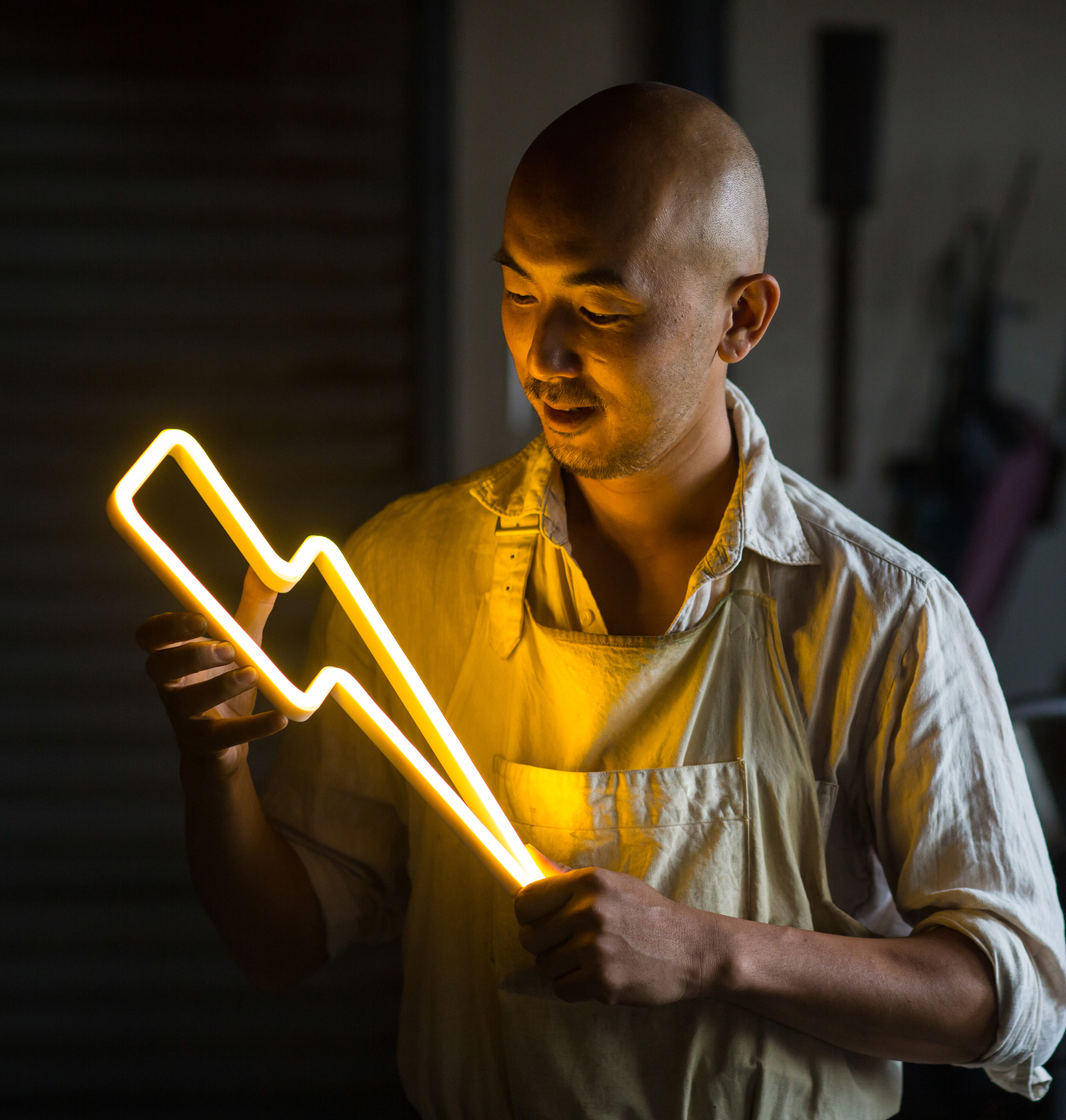Close-up of a person holding a glowing icon-shaped light