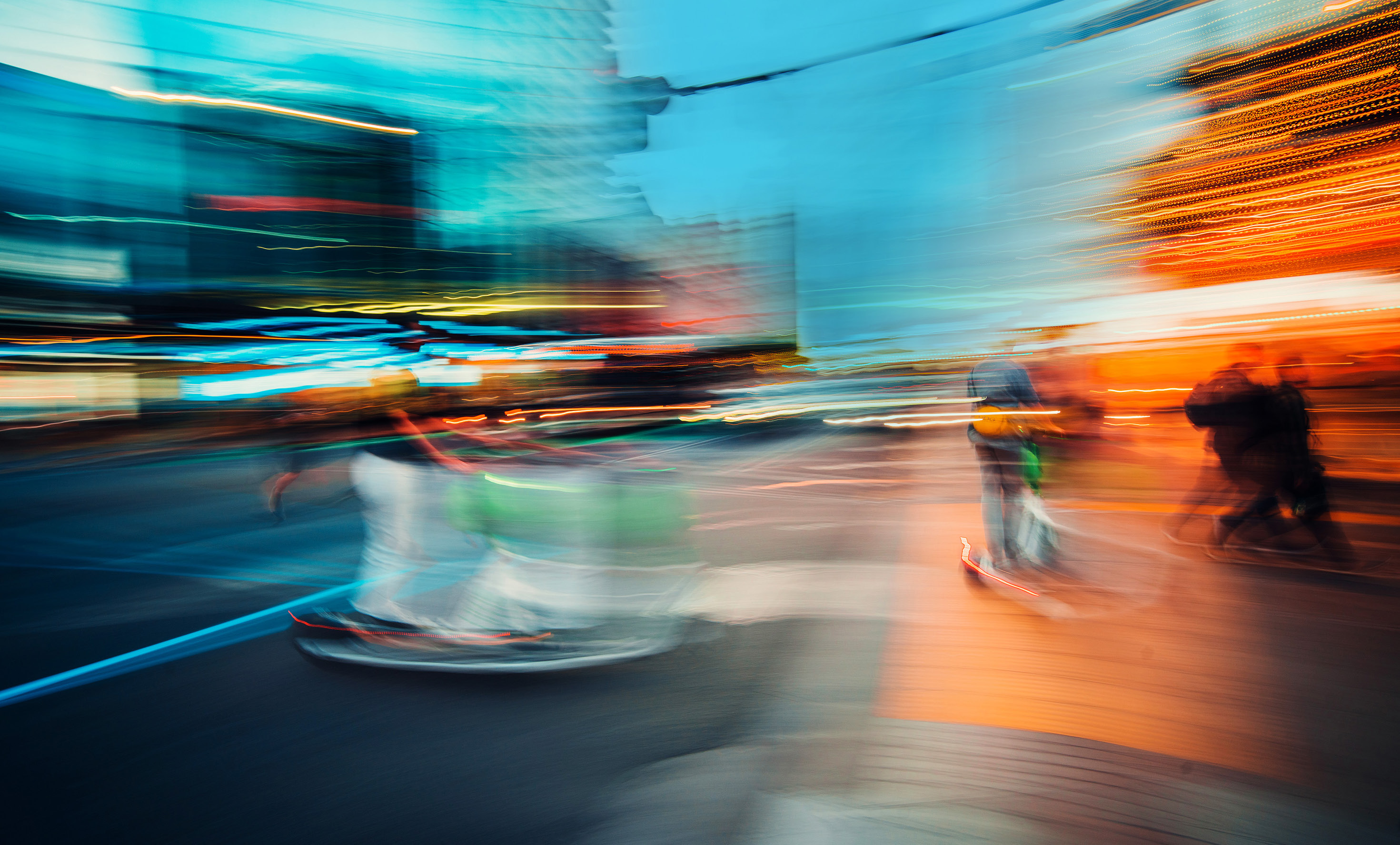 Motion-blurred people and city lights, showing movement through a vivid blue and orange scene